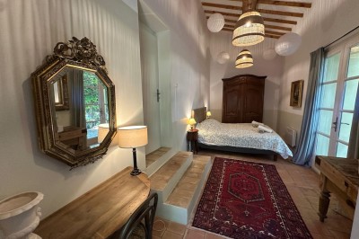 Deux fauteuils en cuir disposés près d'un poêle à bois dans une pièce au mur en bois décorée de cadres et d'une tête d'ours.