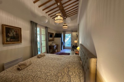 Deux fauteuils en cuir disposés près d'un poêle à bois dans une pièce au mur en bois décorée de cadres et d'une tête d'ours.