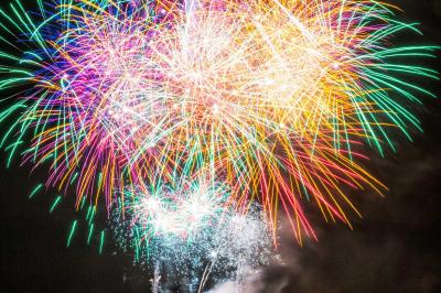 Feux d'artifice avec des traînées dorées et des éclats bleus sur un fond de nuit noire.