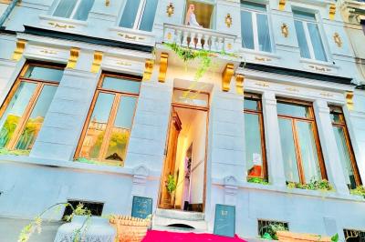 Salle de bain moderne avec lavabo double, miroir, toilettes grises et étagères décorées de plantes et flacons.