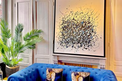 Salle de bain moderne avec lavabo double, miroir, toilettes grises et étagères décorées de plantes et flacons.