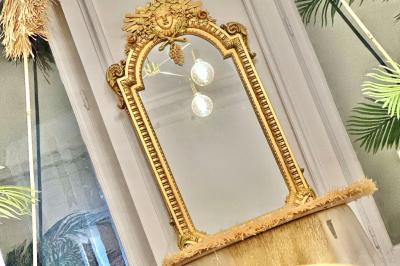 Salle de bain moderne avec lavabo double, miroir, toilettes grises et étagères décorées de plantes et flacons.