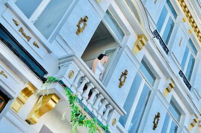Salle de bain moderne avec lavabo double, miroir, toilettes grises et étagères décorées de plantes et flacons.