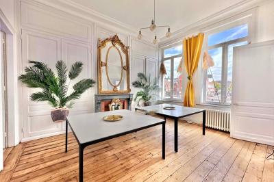 Salle de bain moderne avec lavabo double, miroir, toilettes grises et étagères décorées de plantes et flacons.
