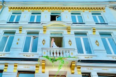 Salle de bain moderne avec lavabo double, miroir, toilettes grises et étagères décorées de plantes et flacons.