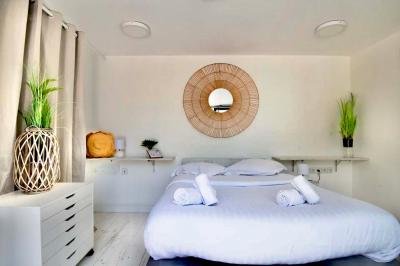 Salle de bain moderne avec lavabo double, miroir, toilettes grises et étagères décorées de plantes et flacons.