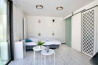 Salle de bain moderne avec lavabo double, miroir, toilettes grises et étagères décorées de plantes et flacons.