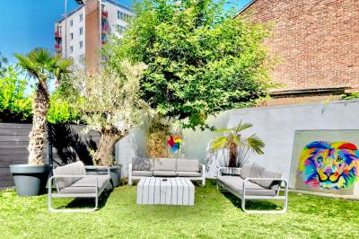Salle de bain moderne avec lavabo double, miroir, toilettes grises et étagères décorées de plantes et flacons.