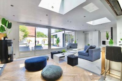 Salle de bain moderne avec lavabo double, miroir, toilettes grises et étagères décorées de plantes et flacons.