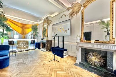 Salle de bain moderne avec lavabo double, miroir, toilettes grises et étagères décorées de plantes et flacons.