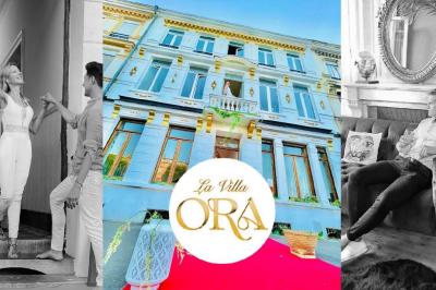 Salle de bain moderne avec lavabo double, miroir, toilettes grises et étagères décorées de plantes et flacons.