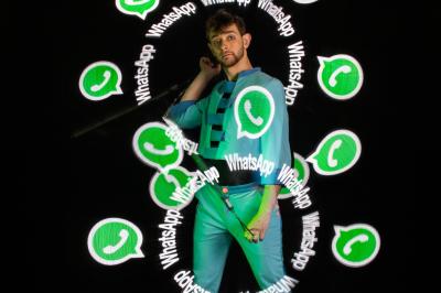 Un jongleur manipule des bâtons rouges dans une galerie lumineuse avec une verrière en arrière-plan.