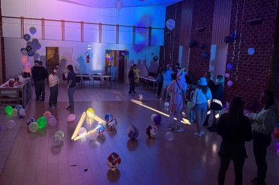 Miniature Anniversaire - thème festival (avis Google). Salle de réception avec murs en pierre, poutres apparentes, tables dressées et éclairage tamisé.