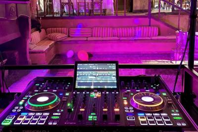 Miniature DJ Mougins (Alpes-Maritimes) - Dj Art Winder #4 Console de DJ avec enceintes sur une terrasse en hauteur, offrant une vue sur la mer et des bâtiments en arrière-plan.