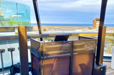 Miniature DJ Mougins (Alpes-Maritimes) - Dj Art Winder #9 Console de DJ avec enceintes sur une terrasse en hauteur, offrant une vue sur la mer et des bâtiments en arrière-plan.