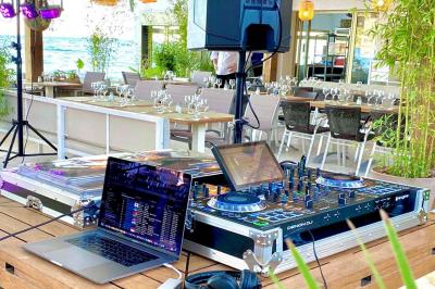 Miniature DJ Mougins (Alpes-Maritimes) - Dj Art Winder #3 Console de DJ avec enceintes sur une terrasse en hauteur, offrant une vue sur la mer et des bâtiments en arrière-plan.