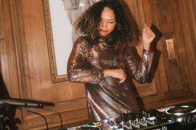 Miniature DJ Alfortville (Val-de-Marne) - Infinia #3 Personne ajustant les commandes d'une table de mixage en plein air, avec de l'herbe en arrière-plan.