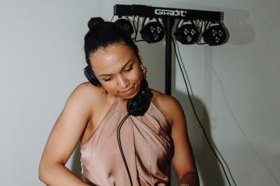 Miniature DJ Alfortville (Val-de-Marne) - Infinia #11 Personne ajustant les commandes d'une table de mixage en plein air, avec de l'herbe en arrière-plan.