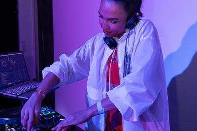 Miniature DJ Alfortville (Val-de-Marne) - Infinia #6 Personne ajustant les commandes d'une table de mixage en plein air, avec de l'herbe en arrière-plan.