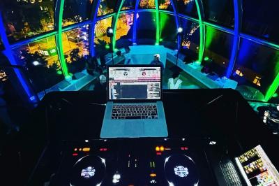 Des invités dansent joyeusement sous des lumières colorées dans une salle décorée pour une fête ou un mariage.