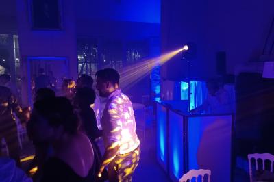Miniature DJ Saint-Pierre-du-Perray (Essonne) - Rem's Dj Event #38 Des invités dansent joyeusement sous des lumières colorées dans une salle décorée pour une fête ou un mariage.