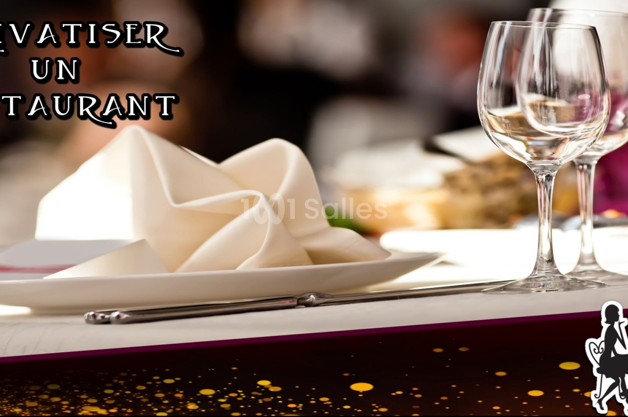 Table élégamment dressée avec serviette pliée, verres à vin et couverts, dans un cadre de restaurant.