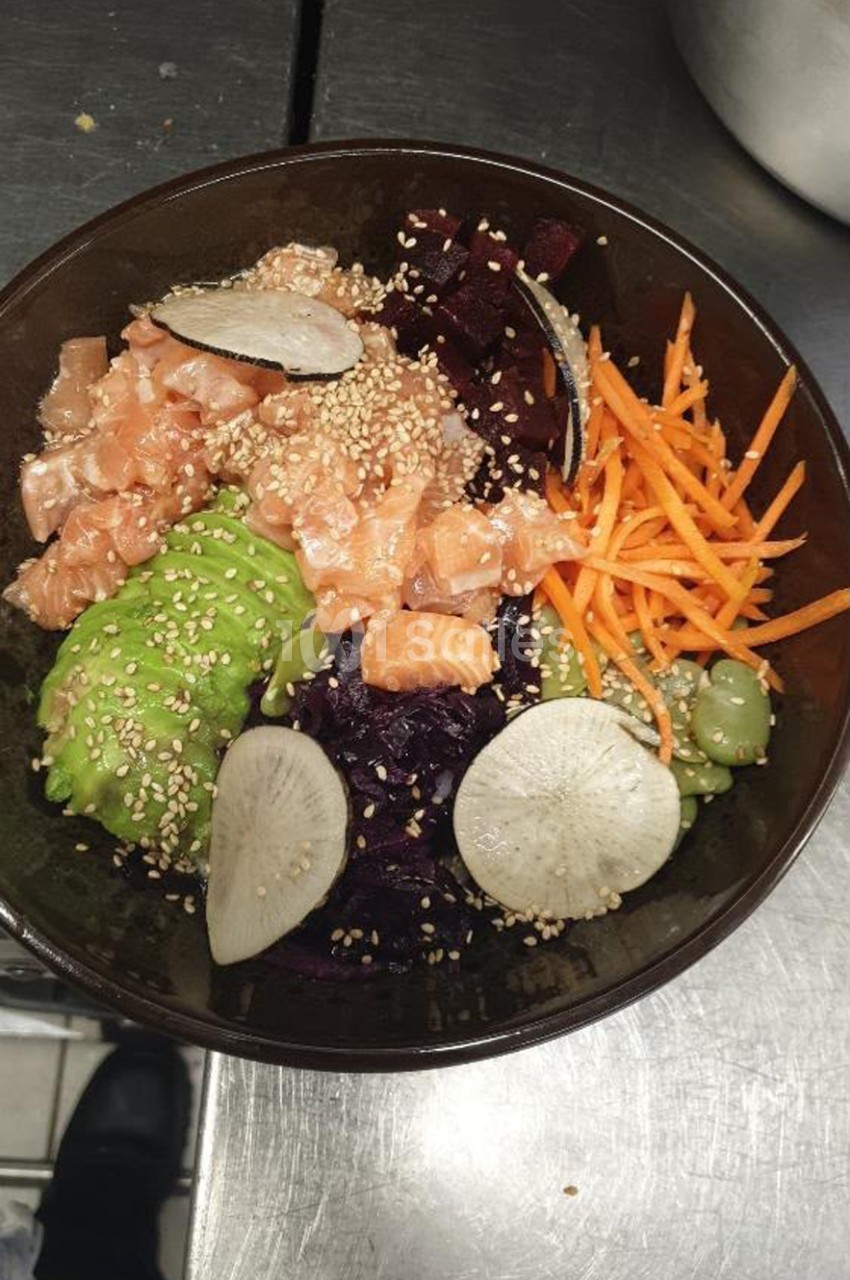 Plat asiatique en bol noir - viande marinée aux graines de sésame, légumes variés et germes de soja.