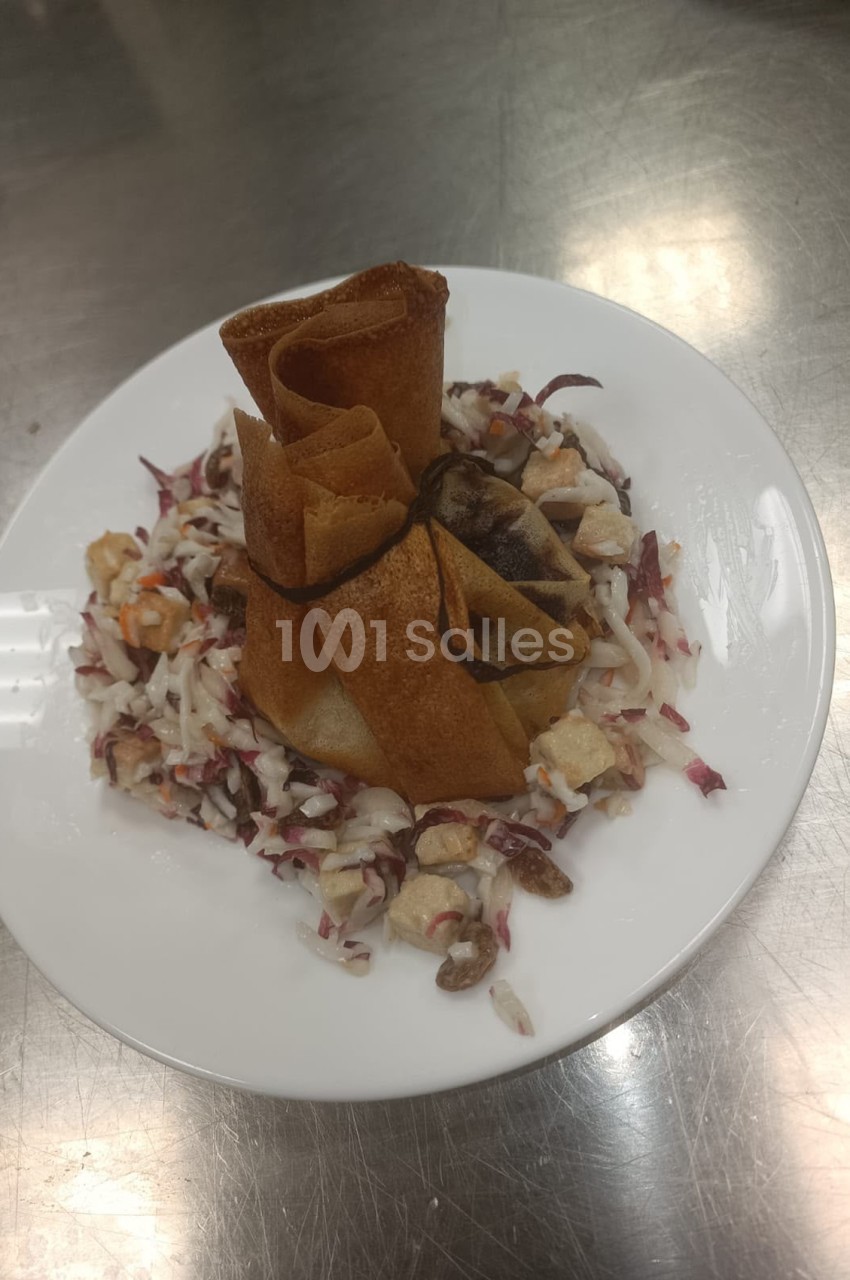 Assiette blanche avec tuiles croustillantes et salade de betteraves rouges, oignons rouges et noix.