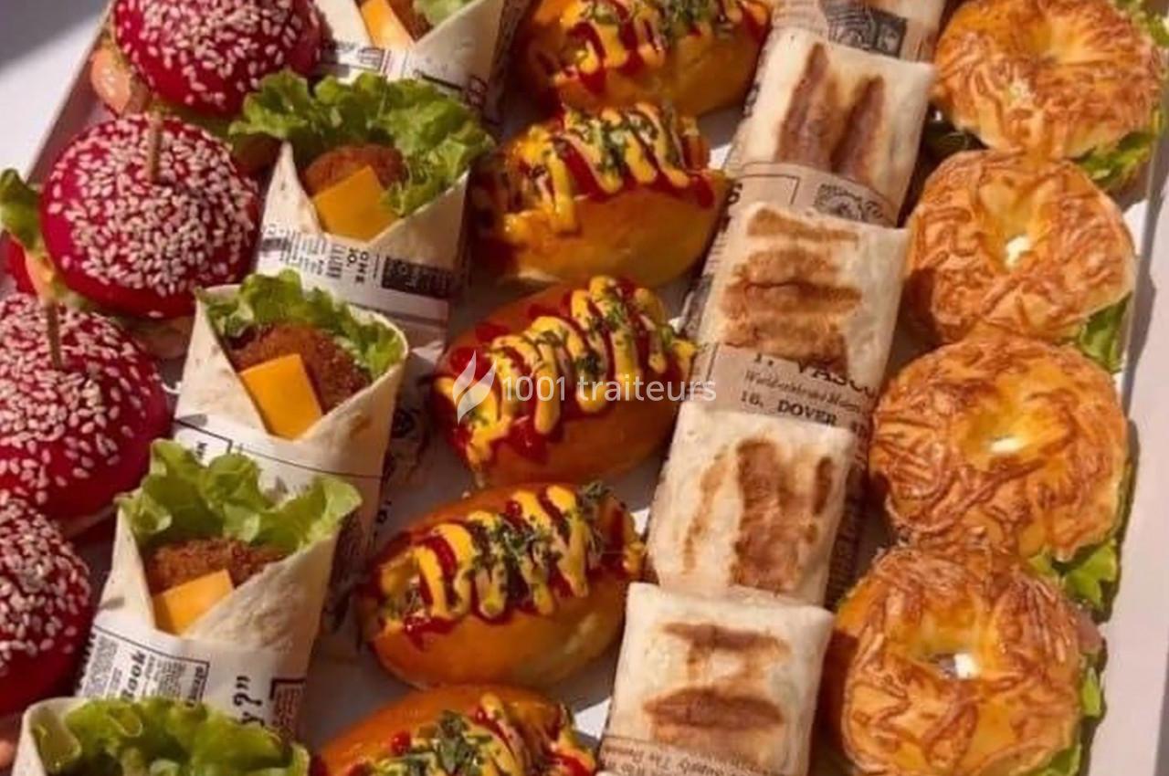 Plateau varié de snacks comprenant mini-burgers, wraps, hot-dogs, feuilletés et pains garnis.