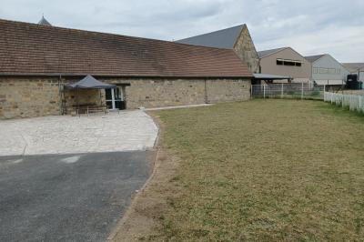 Miniature Location salle Esmery-Hallon (Somme) - La Bergerie #13 Salle de réception en pierre avec tables dressées, décorations florales et bougies, éclairée par la lumière naturelle.