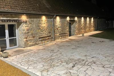 Miniature Location salle Esmery-Hallon (Somme) - La Bergerie #16 Salle de réception en pierre avec tables dressées, décorations florales et bougies, éclairée par la lumière naturelle.