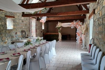 Miniature Location salle Esmery-Hallon (Somme) - La Bergerie #1 Salle de réception en pierre avec tables dressées, décorations florales et bougies, éclairée par la lumière naturelle.