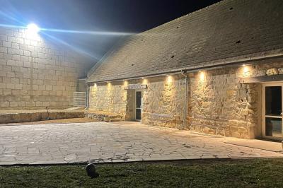 Miniature Location salle Esmery-Hallon (Somme) - La Bergerie #15 Salle de réception en pierre avec tables dressées, décorations florales et bougies, éclairée par la lumière naturelle.