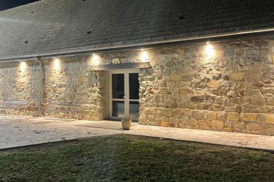 Miniature Location salle Esmery-Hallon (Somme) - La Bergerie #17 Salle de réception en pierre avec tables dressées, décorations florales et bougies, éclairée par la lumière naturelle.