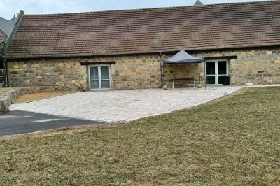 Miniature Location salle Esmery-Hallon (Somme) - La Bergerie #19 Salle de réception en pierre avec tables dressées, décorations florales et bougies, éclairée par la lumière naturelle.