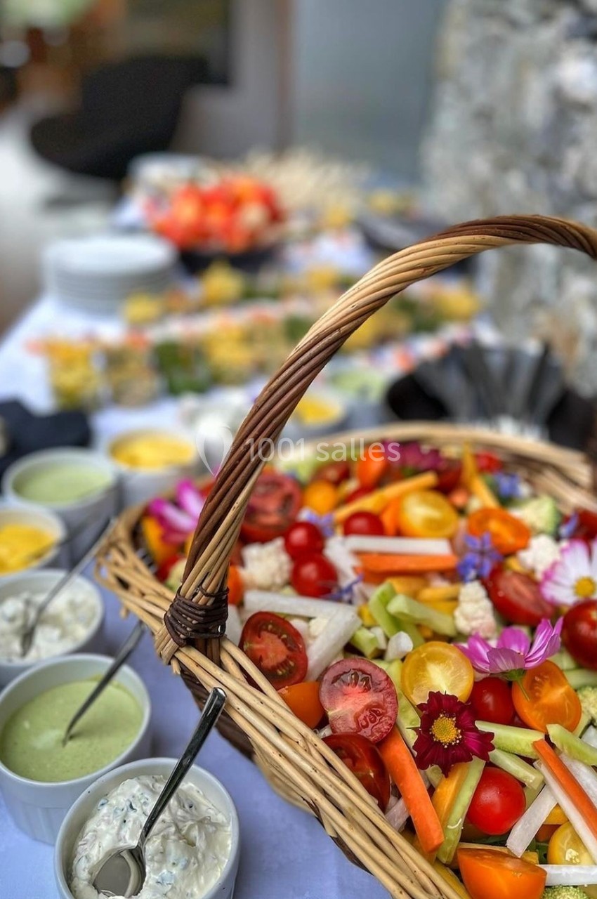 Panier de crudités colorées avec sauces variées en bols, disposé sur une table pour un buffet.