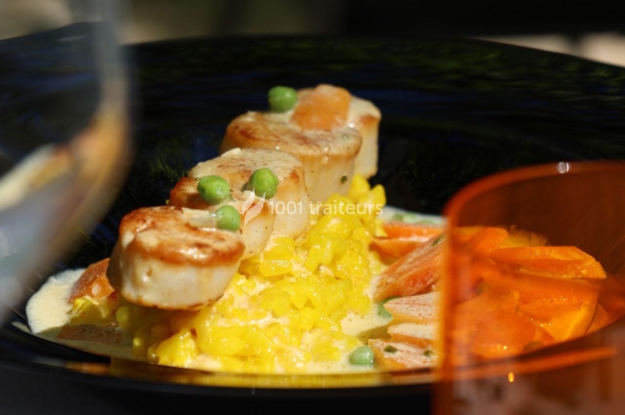 Assiette de noix de Saint-Jacques poêlées avec risotto safrané, petits pois et tranches de carottes.