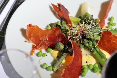 Plat gastronomique composé de viande enroulée, légumes, champignons, sauce brune et garniture de pousses.