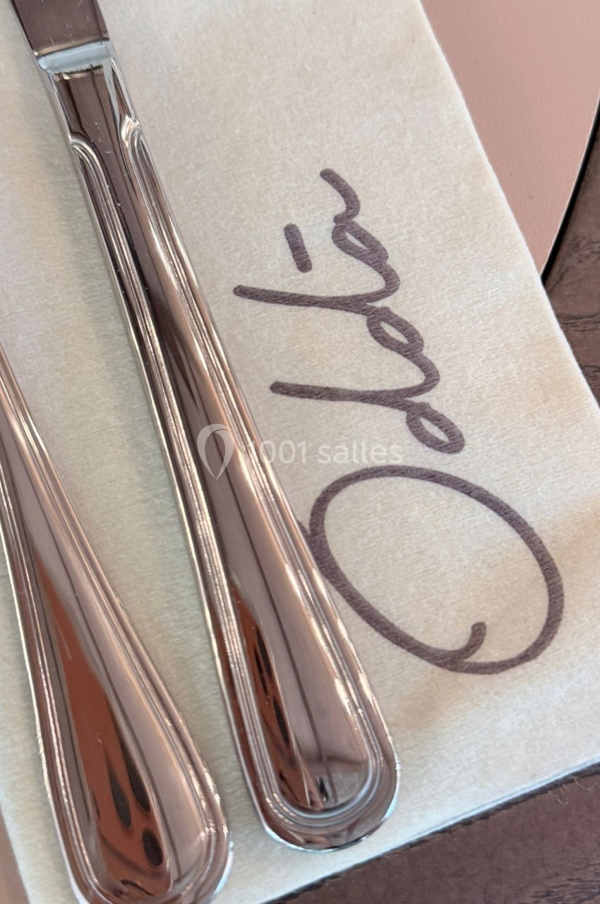 Deux couverts en métal posés sur une serviette beige avec le mot ’Odda’ écrit en lettres manuscrites.