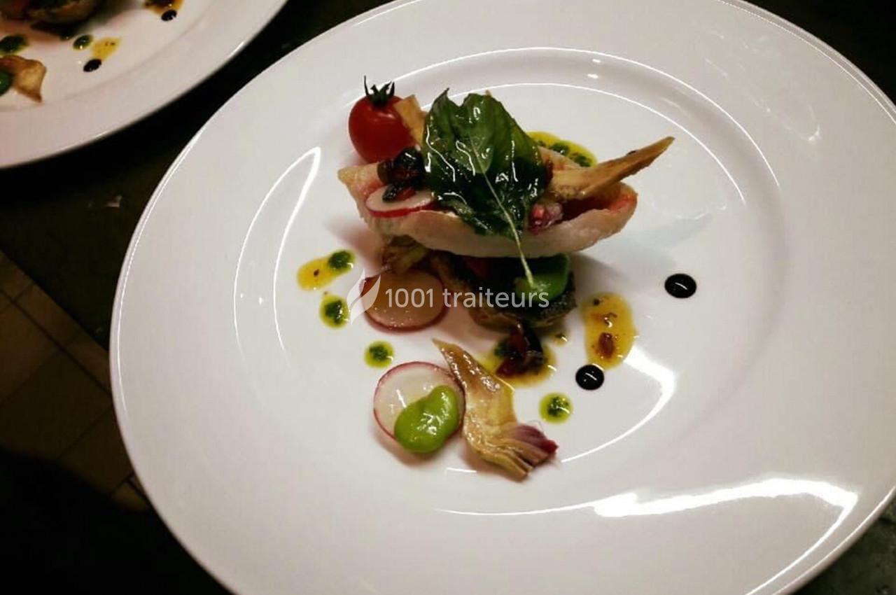 Assiette gastronomique avec filet de poisson, légumes colorés, herbes fraîches et sauces décoratives.