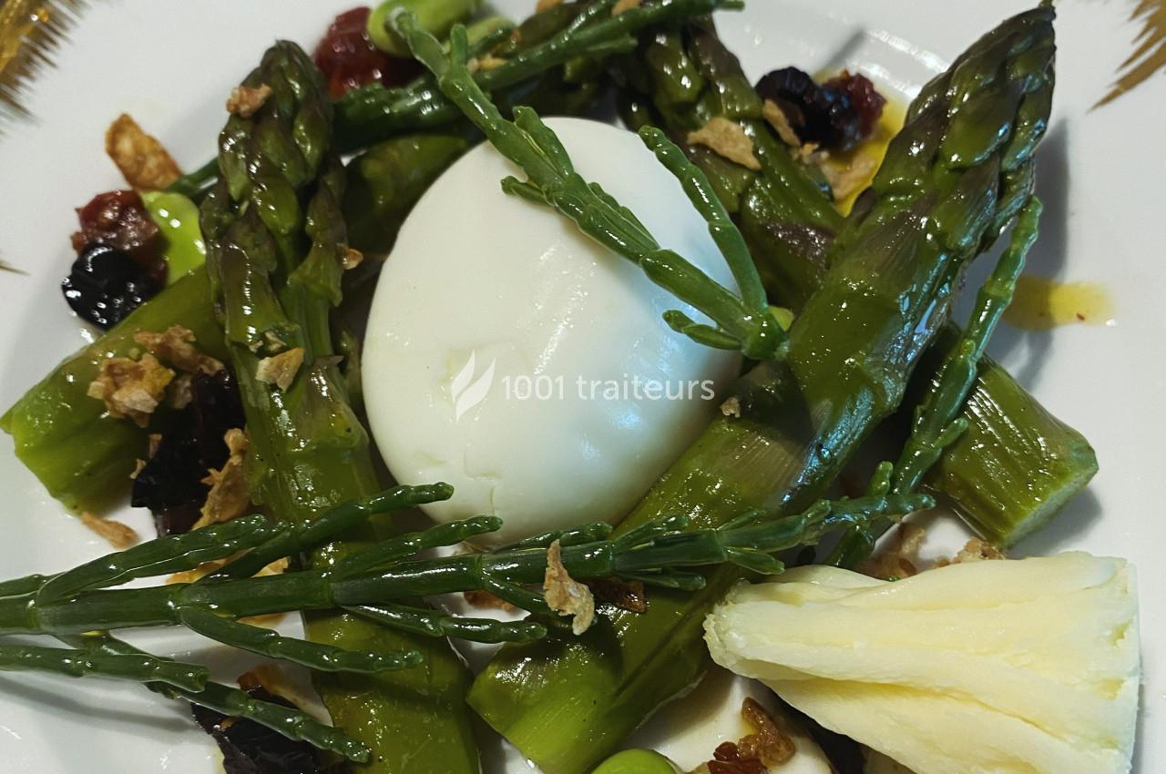 Assiette garnie d'asperges vertes, œuf poché, salicornes, copeaux de fromage et légumes secs.