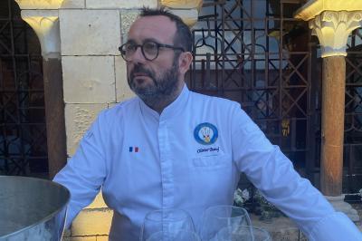 Miniature Traiteur Nice (Alpes-Maritimes) - Boeuf Traiteur #29 Homme en veste de chef blanche, debout devant une architecture en pierre et des grilles métalliques.