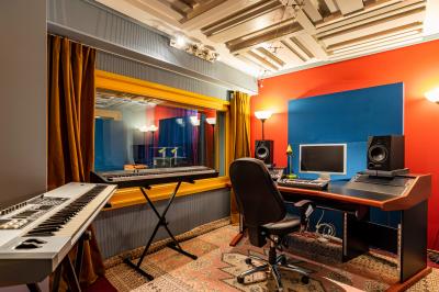 Logo mural des ’Studios Mascaron’ avec un visage stylisé à gauche, en lettres noires sur fond blanc.