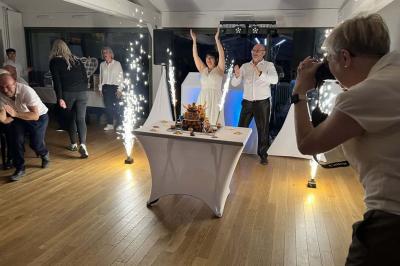 Grande salle en bois avec charpente apparente, éclairages rouges, matériel de sonorisation et espace vide au centre.