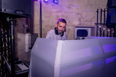 Grande salle en bois avec charpente apparente, éclairages rouges, matériel de sonorisation et espace vide au centre.