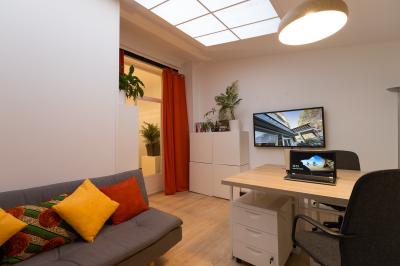 Terrasse en pierre avec mobilier de jardin, entourée de plantes en pots, donnant sur des immeubles en briques.