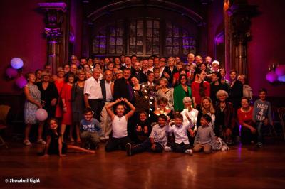 Miniature Showtail Light #21 Un couple danse ensemble dans une salle décorée de ballons, entouré de quelques invités en arrière-plan.