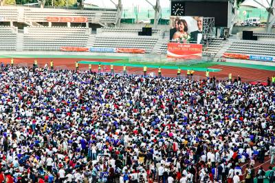 Vue aérienne d'une place animée avec des stands, une statue centrale et des bâtiments historiques environnants.