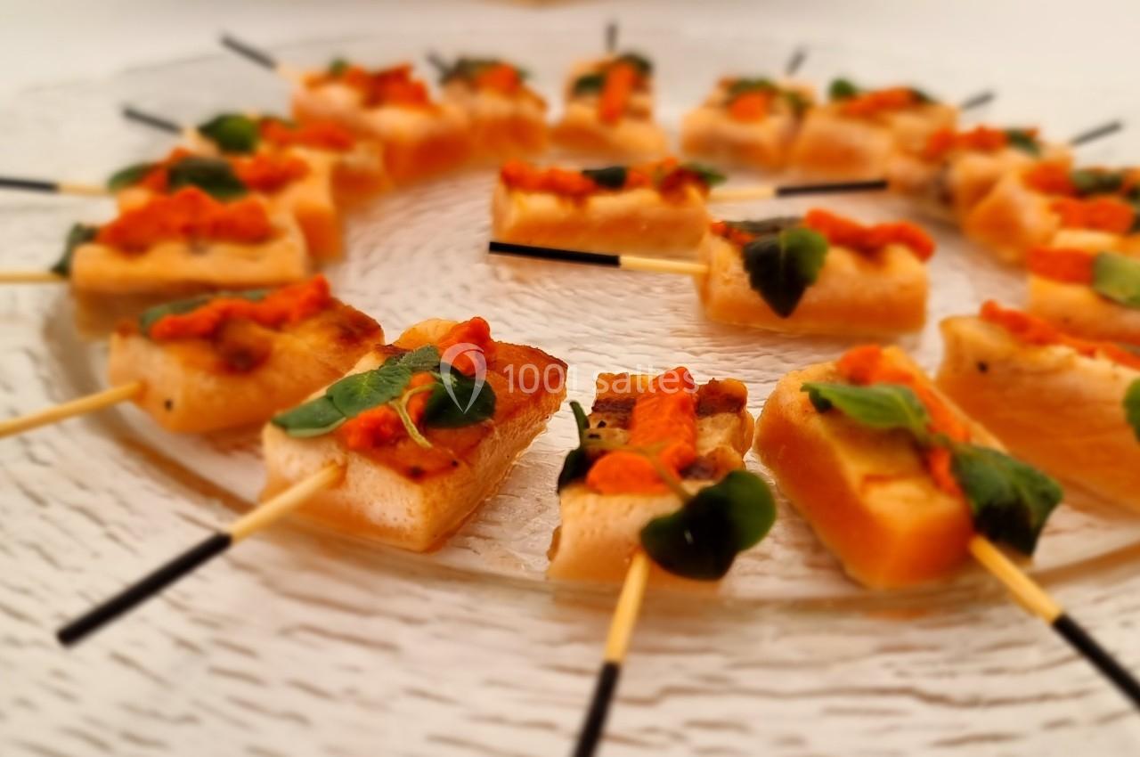 Brochettes apéritives disposées en cercle sur une assiette transparente, garnies de légumes et herbes fraîches.