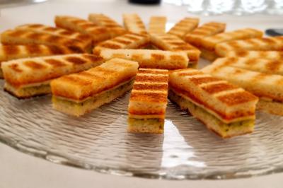 Plateau de pâtisseries garnies de crème blanche, nappées de chocolat et parsemées d'amandes effilées grillées.